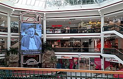 Überblick der zentralen Halle in der Lugner City mit großem Portrait-Foto von Richard Lugner und Hashtag #gemmalugner4ever