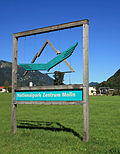 Schild des Zentrums mit Nationalpark-Logo: ein Steinadler vor Gebirgskulisse