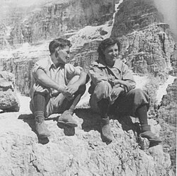 Schwarzweißfoto: ein Mann und eine Frau vor alpiner Bergkulisse sitzend