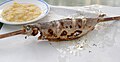 Steckerlfisch wird häufig mit dem Stock in Papier gewickelt serviert
