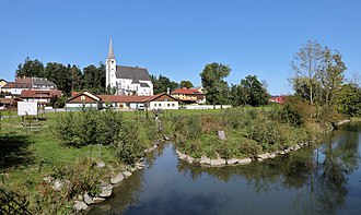 Taufkirchen mit der Pram im Vordergrund und der Pfarrkirche im Hintergrund